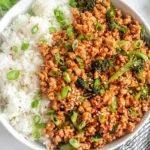 Firecracker Ground Chicken Bowl with sticky spicy-sweet ground chicken, broccoli, sesame seeds, and fluffy white rice topped with green onions.