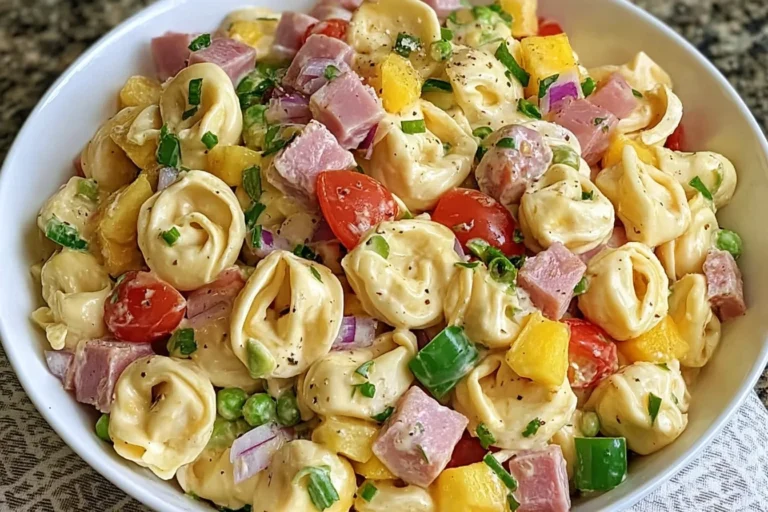 Hawaiian Tortellini Salad with cheese tortellini, ham, pineapple, bell peppers, peas, and creamy teriyaki dressing in a white bowl.