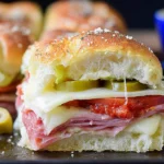 Hot Italian Sub Sliders stacked with ham, salami, pepperoni, melted provolone, and pickled peppers on buttery toasted rolls.