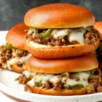 Philly Cheesesteak Sloppy Joes on toasted brioche buns with saucy ground beef, green peppers, onions, and melted provolone cheese.
