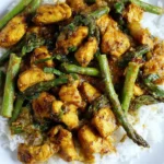 Turmeric Chicken with Asparagus served over fluffy white rice, featuring golden sautéed chicken bites and tender-crisp asparagus in a glossy honey-lime sauce.