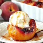 Cinnamon Sugar Baked Peaches topped with vanilla ice cream, baked until golden and syrupy on a rustic dessert plate.