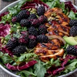 Blackberry Basil Grilled Chicken Salad with grilled chicken, fresh blackberries, avocado slices, arugula, basil, and pumpkin seeds drizzled with blackberry balsamic dressing.