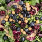 Chickpea Blueberry Salad with fresh blueberries, blackberries, chickpeas, mixed greens, red onion, herbs, and creamy tahini dressing