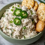 Copycat Jalapeño Hollychicken Salad served in a bowl with creamy shredded chicken, sliced jalapeños, green onions, and crackers for an easy spicy chicken salad recipe.