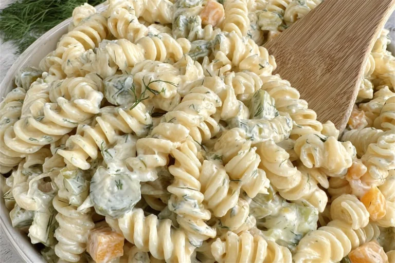 Dill Pickle Pasta Salad in a bowl with creamy dill dressing, rotini, chopped pickles, and Colby Jack cheese.