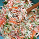 Kani Salad with shredded imitation crab, cucumber, and carrot in creamy Japanese mayo dressing, topped with black sesame seeds.
