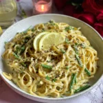 Easy Creamy Lemon Garlic Pasta in a bowl with lemon slices, cracked pepper, parsley, and a creamy Parmesan sauce.