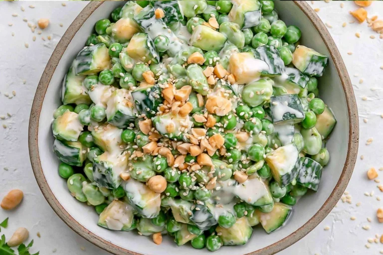 Overhead view of Cucumber Edamame Salad with Creamy Miso Dressing featuring crisp cucumbers, tender edamame, creamy avocado, chopped cashews, and sesame seeds in a savory homemade miso dressing.
