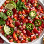Fresh Strawberry Salsa with juicy strawberries, jalapeño slices, red onion, cilantro, and lime, served in a bowl with crispy tortilla chips.