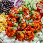 Fiesta Lime Shrimp Bowl with spicy lime-marinated shrimp, white rice, black beans, corn, avocado, cherry tomatoes, red onion, and fresh cilantro.