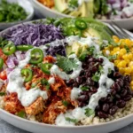 BBQ Ranch Chicken Quinoa Bowls topped with shredded BBQ chicken, quinoa, black beans, corn, avocado, red cabbage, jalapeños, tomatoes, and creamy ranch dressing