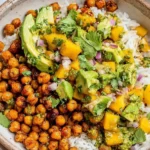 Mango Chickpea Salad bowl with crispy roasted chickpeas, fluffy rice, creamy avocado, juicy mango, red onion, cilantro, and lime.