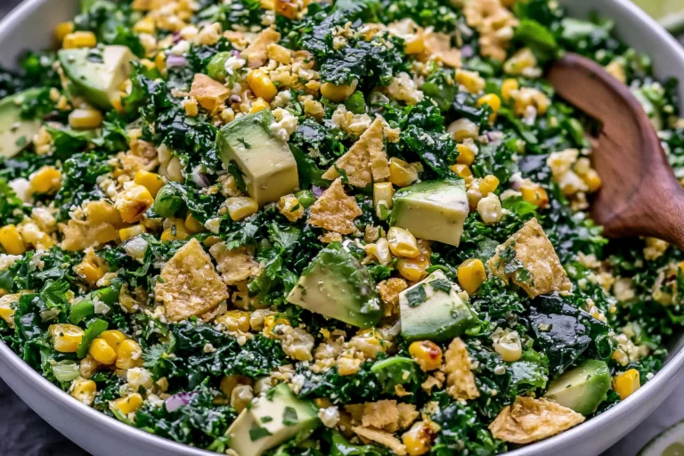 Mexican Street Corn Kale Salad made with grilled corn, fresh kale, creamy avocado, cotija cheese, red onion, and crunchy tortilla chips tossed in a zesty cilantro lime dressing.