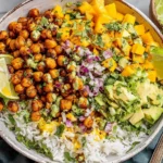 Mango Chickpea Salad bowl with crispy roasted chickpeas, diced mango, avocado, red onion, cilantro, lime, and rice.