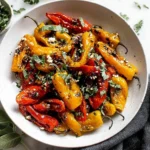Roasted Mini Peppers with balsamic, herbs, and crumbled cheese in a white bowl