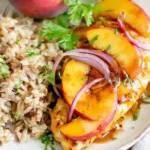 Roasted Peach BBQ Chicken Bake with juicy chicken breast, caramelized peach slices, red onion, and BBQ glaze served with rice and cilantro.