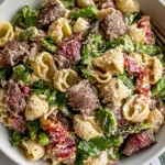 Steak Pasta Salad with tender steak bites, shell pasta, asparagus, bacon, Parmesan cheese, and creamy dressing served in a white bowl.