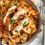 Spicy Chicken Bowtie Pasta served with Cajun-seasoned chicken, creamy Parmesan sauce, and fresh summer vegetables.