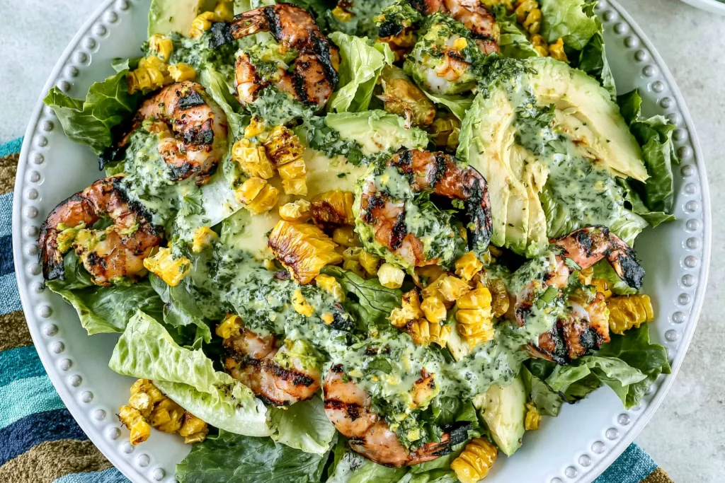 Grilled Shrimp Summer Salad with grilled shrimp, charred corn, avocado, romaine lettuce, and creamy green goddess dressing on a serving platter.