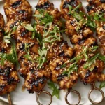 Honey Garlic Asian Chicken Kabobs grilled to perfection with a sticky honey garlic glaze, sesame seeds, and fresh green onions