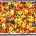 Baked Orzo Roasted Mediterranean Vegetables with Halloumi in a baking dish with roasted tomatoes, zucchini, red onion, eggplant, orzo, and golden halloumi.