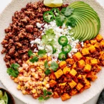 Street Corn Beef Bowl with seasoned ground beef, roasted sweet potatoes, creamy Mexican street corn, avocado, cotija cheese, jalapeños, and fresh cilantro.